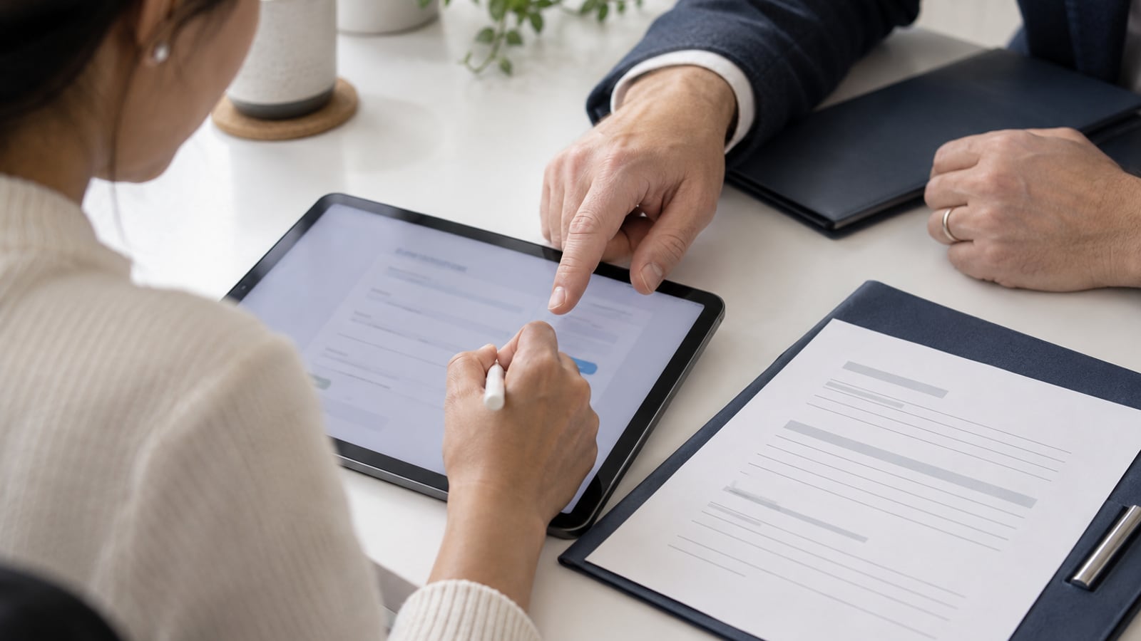 Illustrative close-up of an enrollment form being completed on a tablet beside a paper packet.
